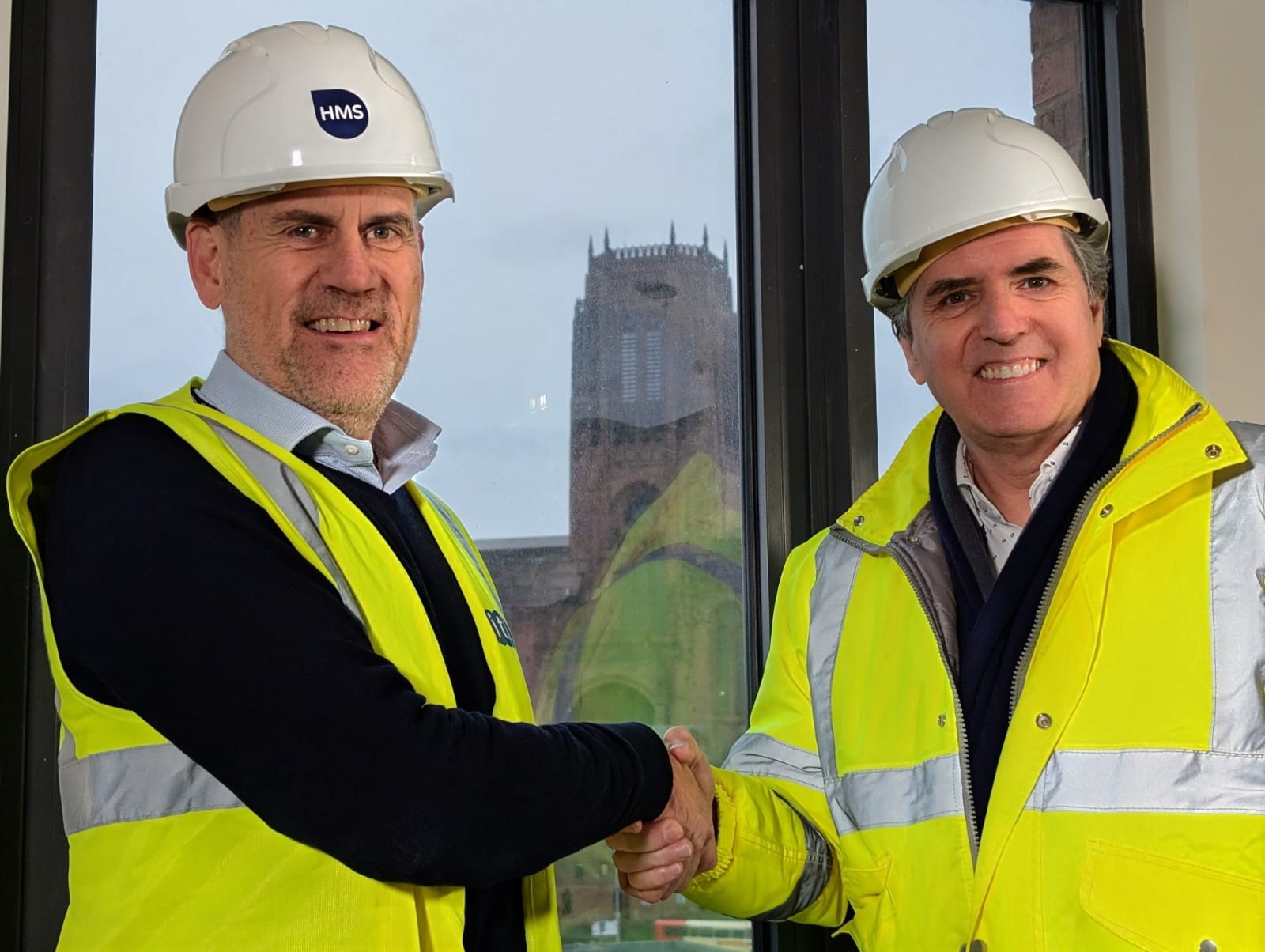 Liverpool City Region Mayor Steve Rotheram and CITB CEO Tim Balcon wearing high vis and hard hats, shaking hands